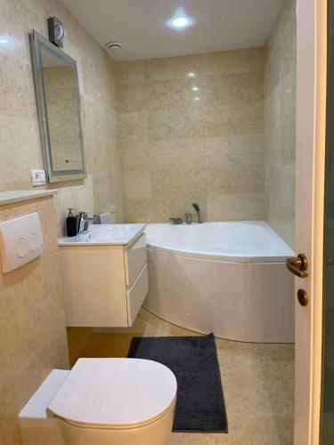 a bathroom with a tub and a toilet and a sink at Scandinavia Mountain View Apartment in Piatra Neamţ