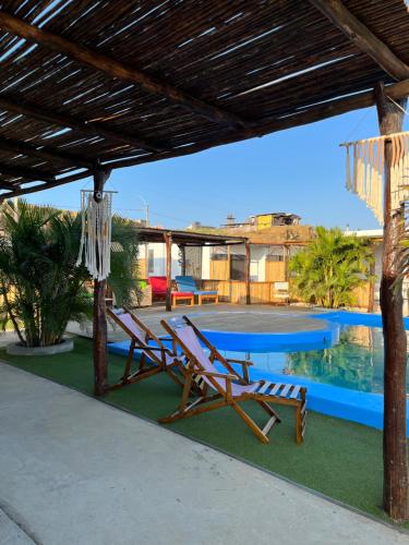 a couple of chairs sitting next to a swimming pool at Aloha Lobitos in Lobitos