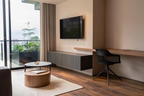 a living room with a tv and a chair at Kiin Living- "Child-free coliving" in Medellín