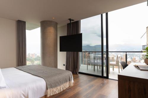 a bedroom with a bed and a large window at Kiin Living - Adults Only in Medellín