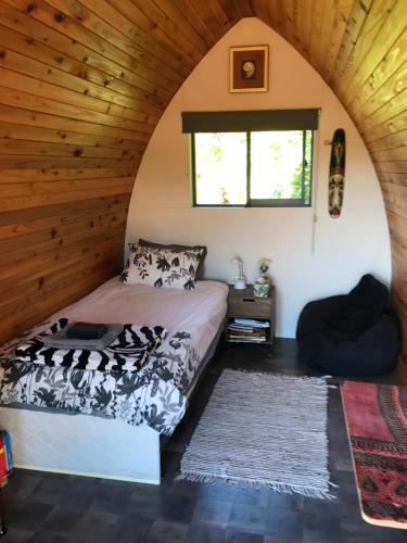 a bedroom with a bed in a room with wooden ceilings at The Dome Waikino in Waikino