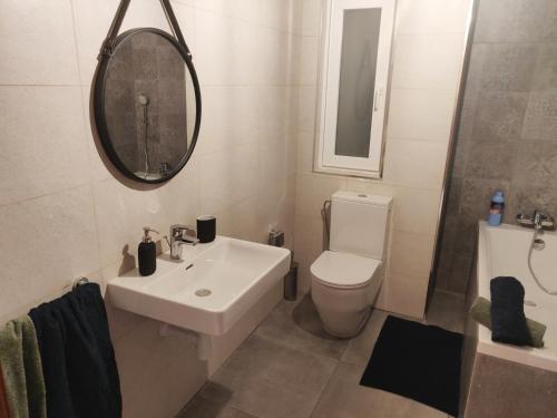 a bathroom with a sink and a toilet and a mirror at Central Malta Apartment in Birkirkara