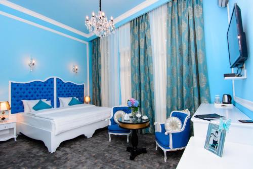 a blue bedroom with a bed and a table and chairs at River Side Hotel Tbilisi in Tbilisi City