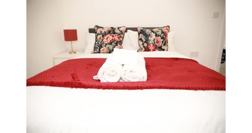 a bedroom with a bed with two towels on it at Cricklewood Deluxe Ensuite Room in London