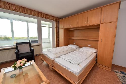 1 dormitorio con 1 cama, 1 silla y 1 mesa en Haus "Atlantic" Appartement ATL303, en Cuxhaven