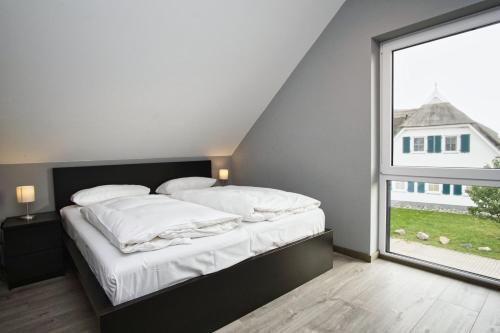 a bed in a room with a large window at Haus in idyllischer Lage mit Sauna, Terrasse und Garten - Villa Mondlicht in Vaschvitz