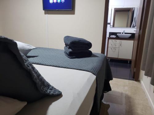 um quarto com uma cama com toalhas em Hospedagem Costa BNU - Q2 em Blumenau