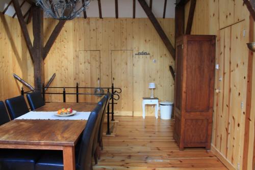 a dining room with a table and a wooden wall at Bed & Breakfast De Stolp in Zuidoostbeemster