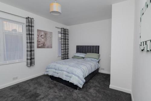 a bedroom with a bed and a window at The house in Barking