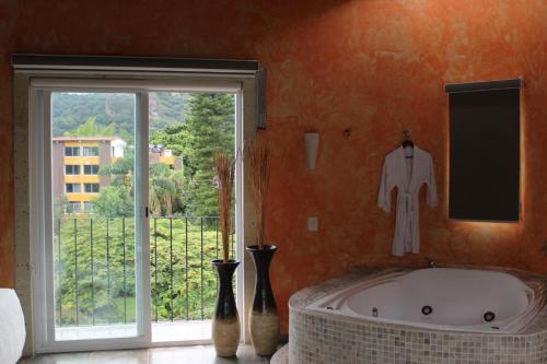 łazienka z dużą wanną i oknem w obiekcie Nequi Hotel Boutique w mieście Tepoztlán