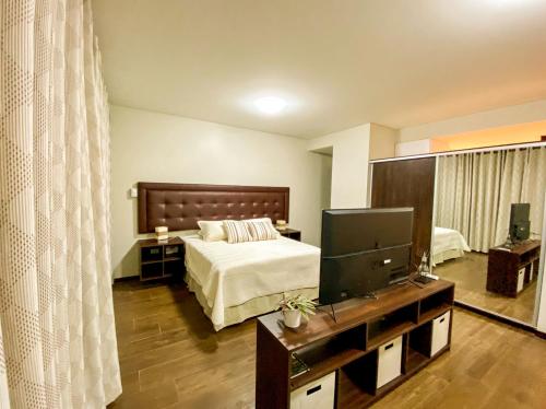 a bedroom with a bed and a flat screen tv at Departamento Elegante y Relax by Torre Vento in Santa Cruz de la Sierra