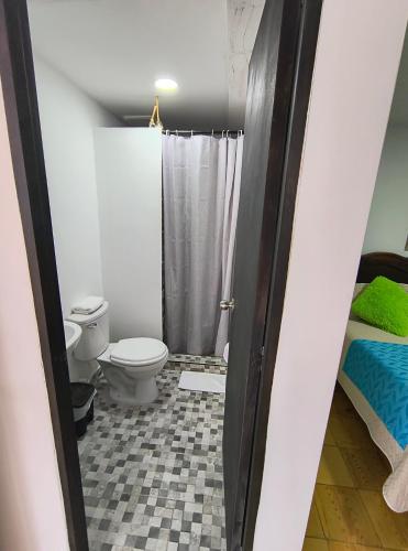 ein Bad mit einem WC und einer Dusche in der Unterkunft Hostal Villa del Sol in Salento