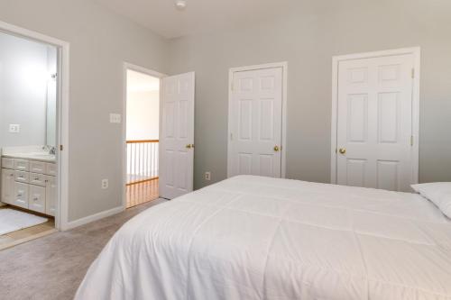 a white bedroom with a large bed and a bathroom at Springfield Sanctuary with Spacious Deck! in Springfield