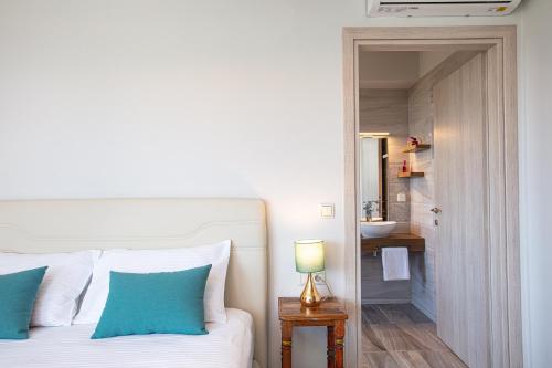 a bedroom with a bed and a bathroom with a sink at Aléa Villa Plakias in Plakias