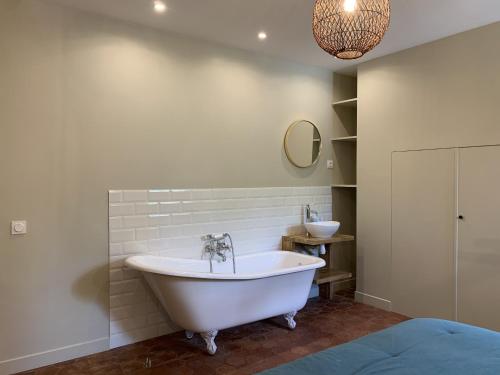 a white bath tub in a bathroom with a sink at Le Grand Monnet - Parc - 16 personnes - Rêve au Mans in Coulaines