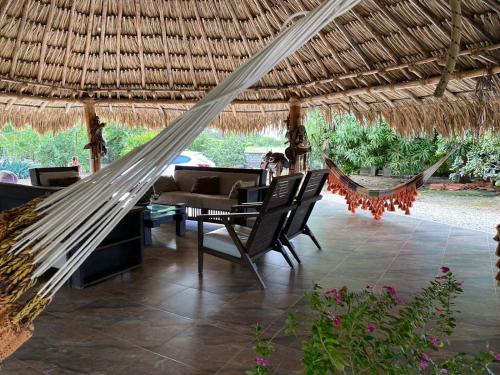 a hammock in a resort with a table and chairs at El Hotel De La Tía in San Bernardo del Viento