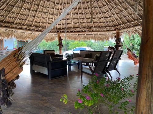 a porch with a hammock and a table and chairs at El Hotel De La Tía in San Bernardo del Viento