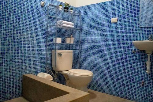 uma casa de banho em azulejos azuis com um WC e um lavatório em Casa de Campo Privada con Piscina en Cieneguilla em Cieneguilla