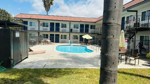 un edificio con piscina en un patio en Studio 6 Suites San Ysidro CA San Diego South Bay, en San Ysidro