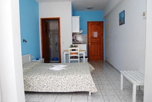 1 dormitorio con 2 camas y pared azul en Elena Studios, en Patitiri