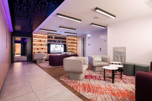a waiting room with couches chairs and a tv at YOTEL Porto in Porto
