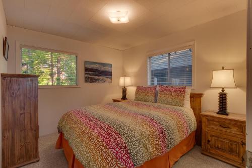 1 dormitorio con 1 cama y 2 ventanas en Evans Lakeview- Hot Tub- Fireplace- Walk To Lake- Minutes to Homewood Resort, en Homewood