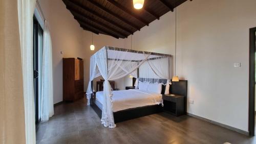 1 dormitorio con 1 cama con dosel en The Ridge House en Kandy