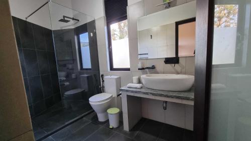 y baño con lavabo, aseo y ducha. en The Ridge House en Kandy