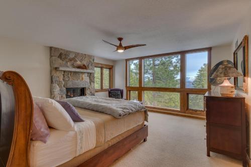 a bedroom with a bed and a stone fireplace at Kings Way Lake View by Tahoe Getaways - Spacious 4 BR w Private Hot Tub, Pool Table! in Tahoe Vista