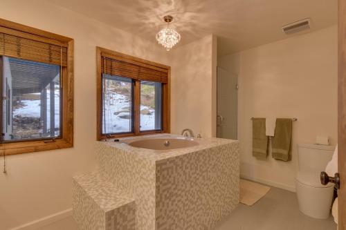 La salle de bains est pourvue d'une grande baignoire et d'une fenêtre. dans l'établissement Kings Way Lake View - Spacious 4 BR w Private Hot Tub, Pool Table!, à Tahoe Vista