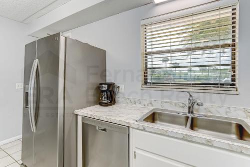 a kitchen with a stainless steel refrigerator and a sink at Amelia By The Sea 110 in Fernandina Beach