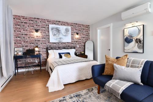 a bedroom with a bed and a brick wall at Jardin Suites Highfield in Moncton