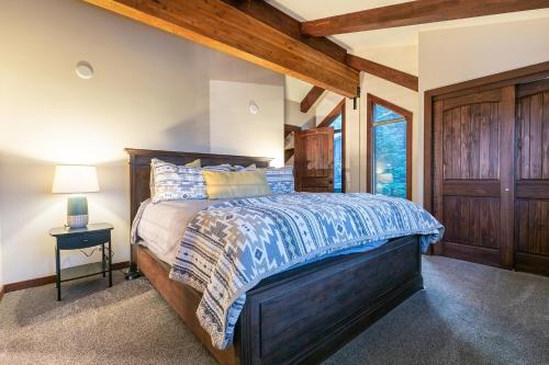 タホシティにあるLake of the Sky at Dollar Point - Stunning 4BR,4BA w Lake Views, Hot Tub and Pet-friendlyの木製のヘッドボードが付いた大きなベッドのある寝室