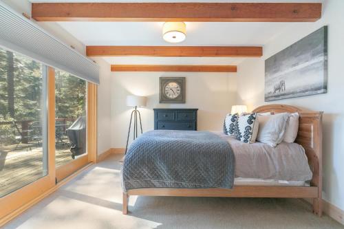 1 dormitorio con cama y ventana grande en Lupine Lodge at Tahoe Park on the West Shore - Hot Tub, Beach Access, Near Ski Resorts! en Tahoe City