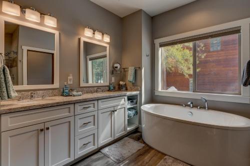 a bathroom with a tub and two sinks and a window at Mountain Jewel in Tahoe Donner - Beautiful 4 Bedroom w Hot tub, Access to HOA Amenities in Truckee
