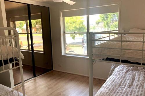 ein Schlafzimmer mit einem Etagenbett und einem Fenster in der Unterkunft Spacious Unit in Convenient Location in Yarrawonga