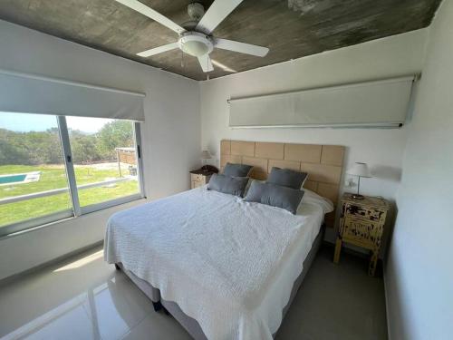 a bedroom with a bed and a ceiling fan at Tranquilidad, playa y naturaleza in José Ignacio