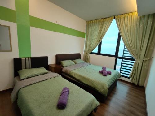 twee bedden in een kamer met paarse kussens erop bij A.Foo Homestay 4.2 @ Vivacity Megamall Jazz Suite 4 in Kuching