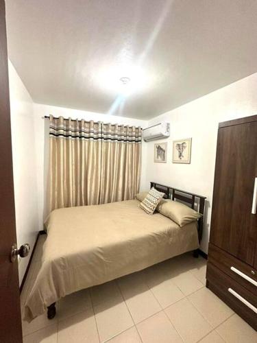 a small bedroom with a bed with a curtain at Casa Mercado III in Lipa