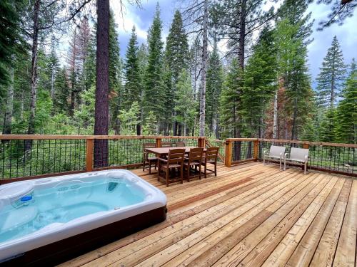 a deck with a hot tub and a table and chairs at Snowbird Retreat at Northstar - Beautiful 4BR with Private Hot Tub, Free Ski Shuttle, HOA Amenities in Truckee