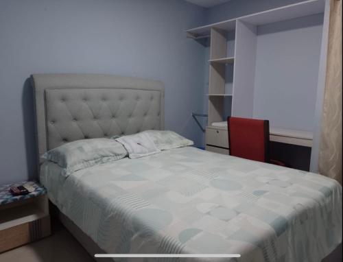 a bedroom with a bed and a red chair at Apto 3 habit +2TV-Wifi, Netflix-Parqueadero gratis in Barranquilla
