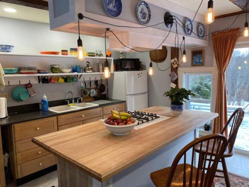 a kitchen with a bowl of fruit on a kitchen island at The Apartment at Sky Hollow in Rochester
