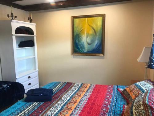 ein Schlafzimmer mit einem Bett und einem Wandgemälde in der Unterkunft The Apartment at Sky Hollow in Rochester
