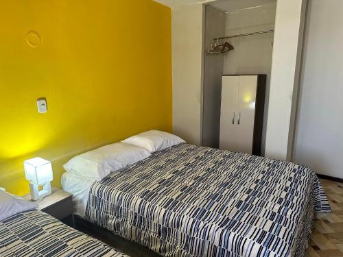 阿雷基帕的住宿－San Gregory，一间卧室设有两张床和黄色的墙壁