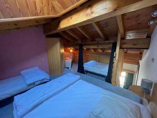 two beds in a room with wooden ceilings at Appartement 6-8 personnes à 3 minutes des pistes in Peisey-Nancroix