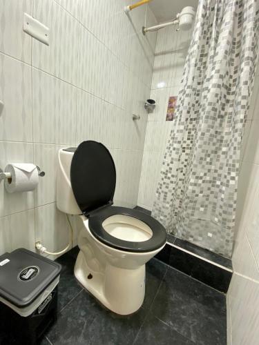 a bathroom with a toilet with a black seat and a shower at Habitación Privada Cerca al Aeropuerto in Bogotá