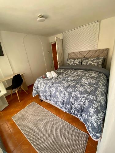 a bedroom with a bed with a blue and white comforter at Habitación Privada Cerca al Aeropuerto in Bogotá