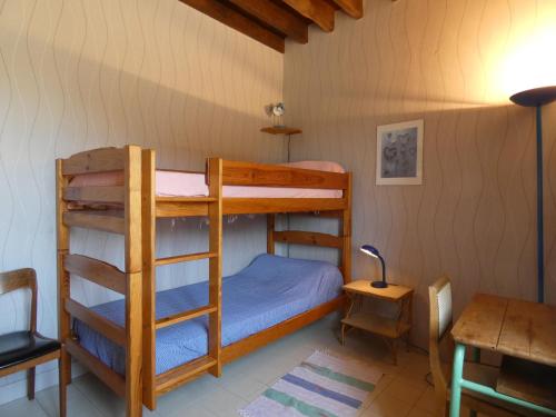 une chambre avec deux lits superposés et un bureau dans l'établissement Charmante maison de ferme avec pigeonnier, jardin, cheminée et salle de jeux à Aufferville - FR-1-581-38, à Luplanté