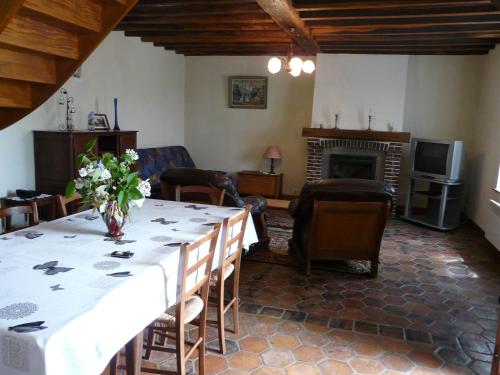uma sala de estar com uma mesa e uma lareira em Gîte La Saucelle, 3 pièces, 4 personnes - FR-1-581-13 