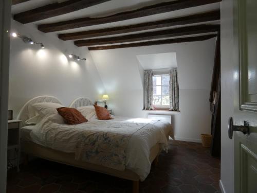 een slaapkamer met een bed met witte lakens en een raam bij Gîte Garnay, 3 pièces, 4 personnes - FR-1-581-103 in Garnay